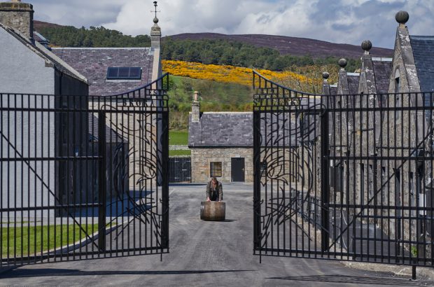 Master Distiller Stewart Bowman rolls a whisky barrel through the gates at Brora Scotch Whisky Distillery