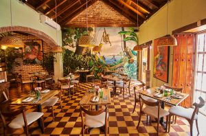 Restaurant interior with tables and chairs and a colourful mural