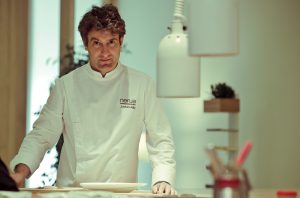 A chef standing behind a counter in a restaurant