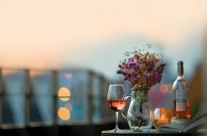 Glass and bottle of rosé wine on a table