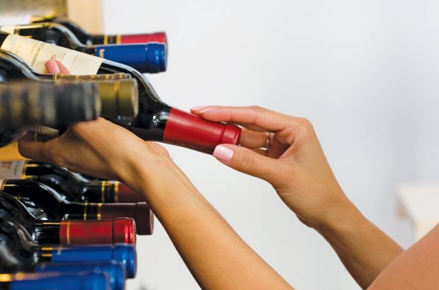 Taking a bottle of wine from a rack