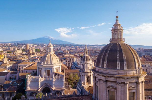 Domes around Sant'Agata cathedral in central Catania with Mount Etna in the background to the north.