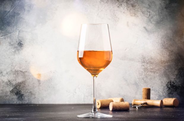 A glass of orange wine with corks