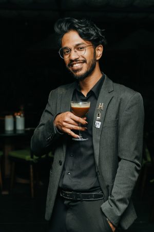 A man in a dark bar holding a cocktail