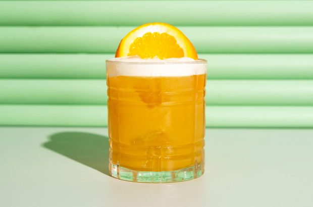 Orange cocktail against a green background