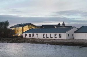 A white distillery building by the sea