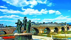 A statue next to a stone bridge