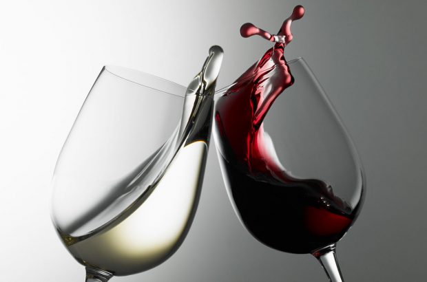 Glass of white wine and glass of red wine clinking