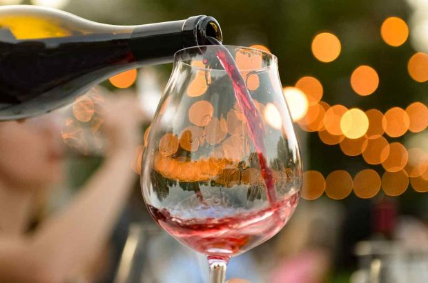 Pouring a glass of red wine from a bottle