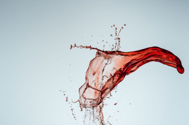 Splash of red wine on blue background