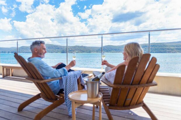 Image of couple on sun deck drinking sparkling wine.
