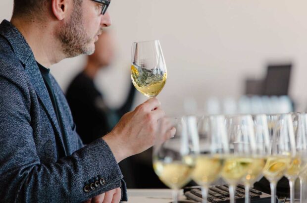 Image of a wine judge assessing a white wine.