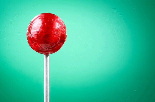red lollipop sweet on green background