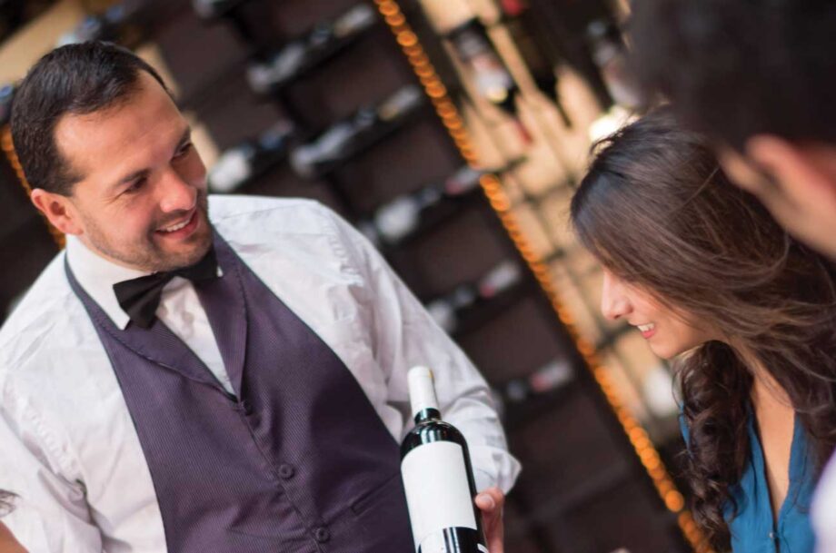 Sommelier showing bottle of wine to a customer