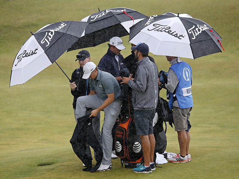 Jordan Spieth puts on his waterproofs