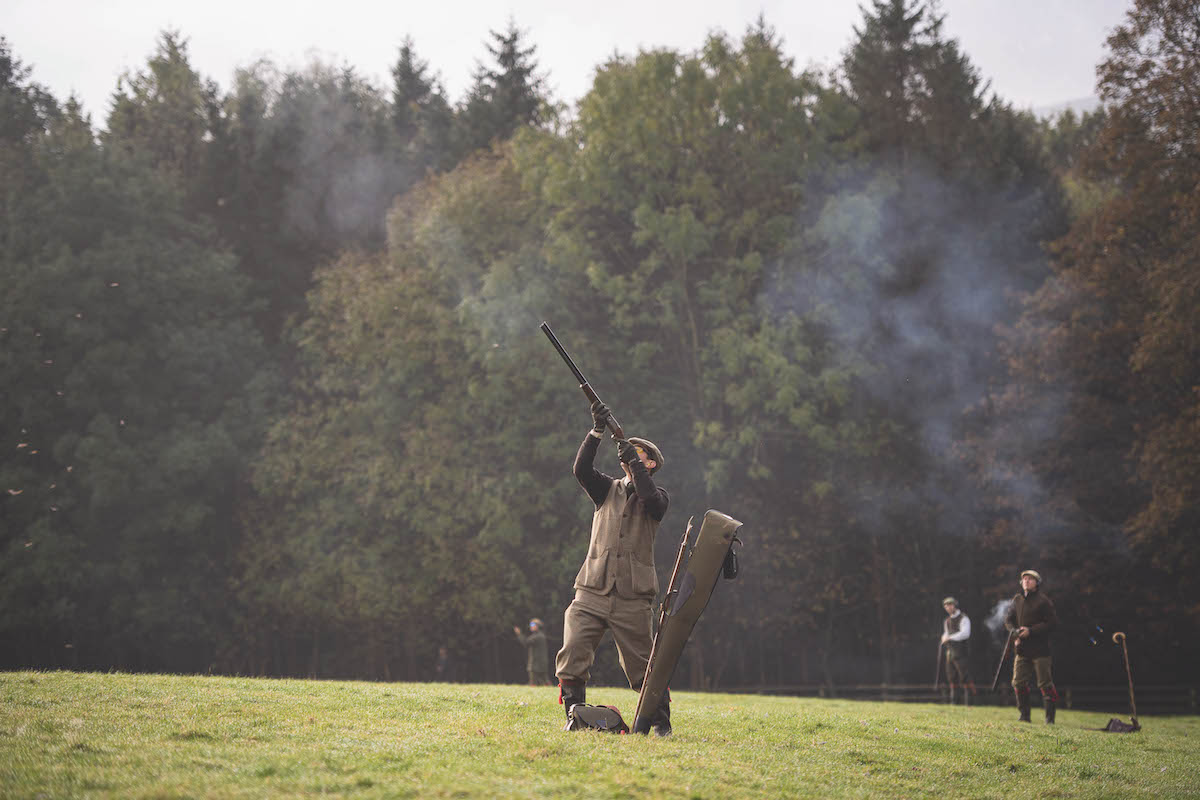 Man shooting gun in field