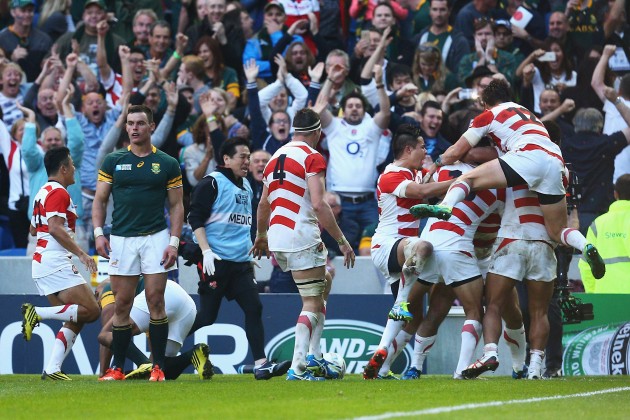 Stunning score: Jubilant Japan celebrate Karne Hesketh's winning try against South Africa