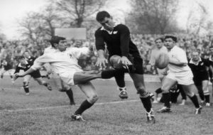 Colin Meads charges down a kick