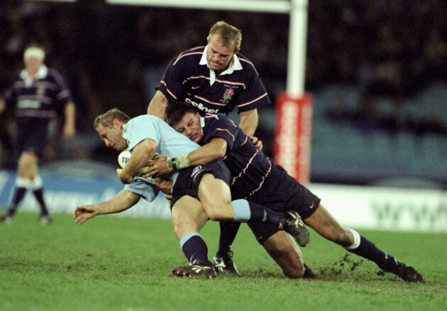 England's Martin Corry tackles an Australia player, while wearing a dark blue tribute to an old British & Lions kit in 1999