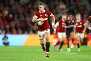 The British & Irish Lions’ Huw Jones runs with the ball during the 2025 match against Queensland Reds.
