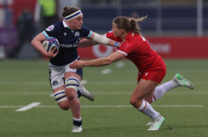 Scotland's Rachel McLachlan runs with the ball as Wales' Caryx Cox attempts a tackle during the 2025 Six Nations match.