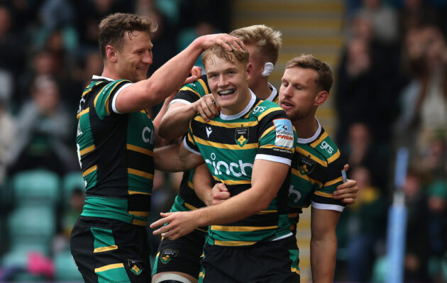 Fin Smith surrounded by Northampton Saints after scoring his team's first try in the Gallagher PREM match against Leicester Tigers