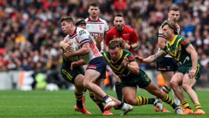 England's Jack Welsby is tackled by Australia's Lindsay Collins Reuben Cotter with Cameron Munster close by during the Rugby League Ashes match between England and Australia at Wembley Stadium on October 25, 2025 in London, England.