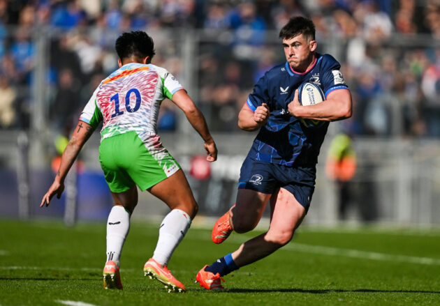 Leinster's Dan Sheehan runs with the ball as Harlequins' Marcus Smith prepares to challenge during the 2025 European Rugby Champions Cup round-of-16 match.