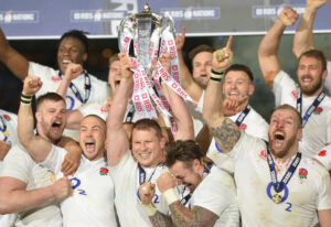 Dylan Hartley, surrounded by England teammates, lifts the 2016 Six Nations trophy