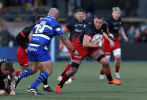 Tom Willis of Saracens runs with the ball as Bath's Tom Dunn prepares to make a challenge in the Gallagher PREM match in November 2025