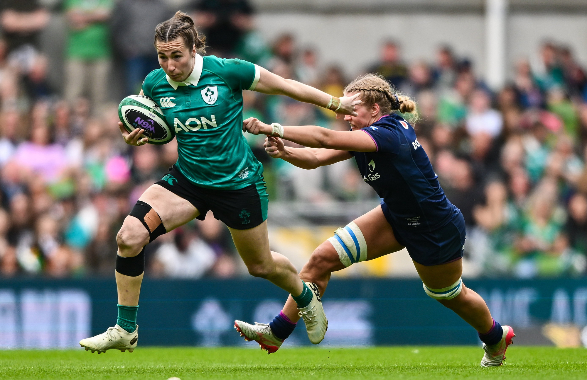 Ireland's Eve Higgins runs away from a tackle by a Scotland player during the 2026 Six Nations clash in Dublin.