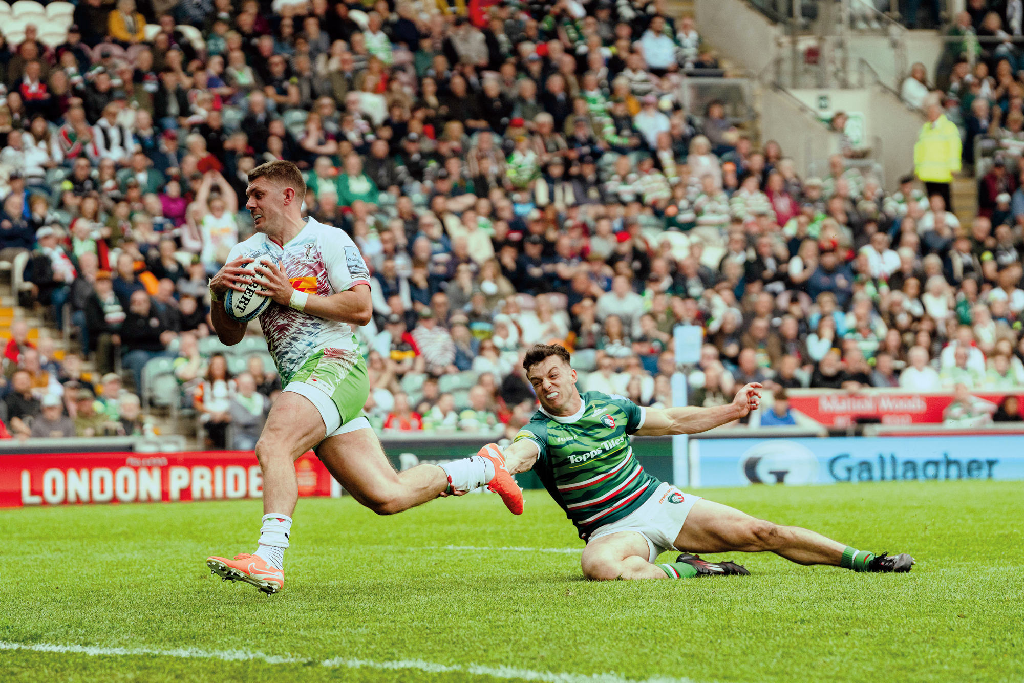 Luke Northmore, do Harlequin, escapa de um ataque de Adam Radwan, do Leicester Tigers