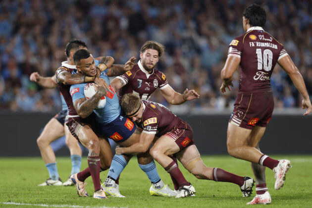 The Blues’ Addin Fonua-Blake is tackled by Maroons players during the first State of Origin game of 2026.