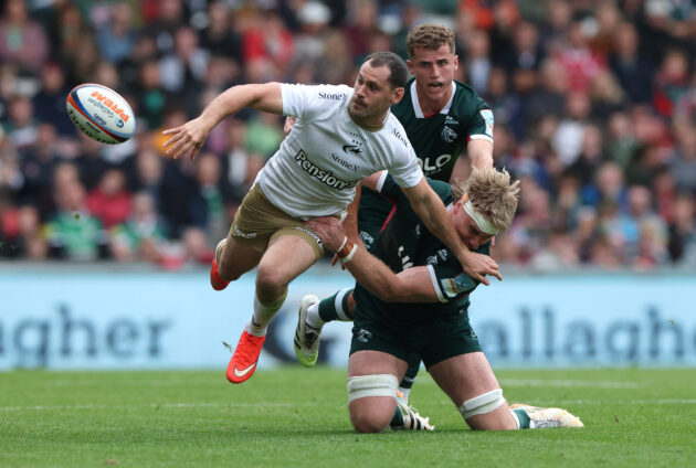 Saracens' Tomos Williams offloads as Leicester Tigers' Aaron Wainwright challenges during the September 2026 Gallagher PREM encounter.