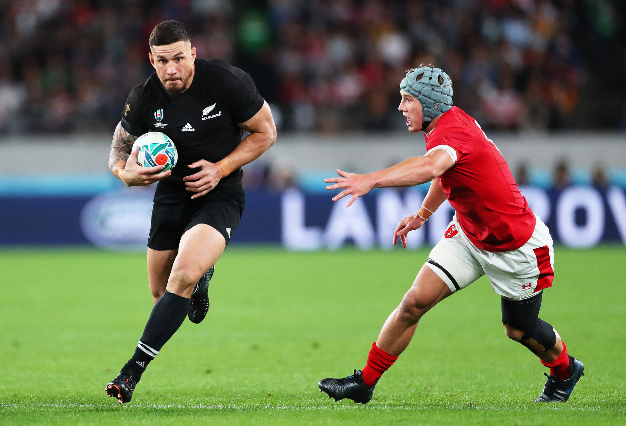 New Zealand's Sonny Bill Williams runs past Wales' Jonathan Davies during the Rugby World Cup 2019 bronze medal match.